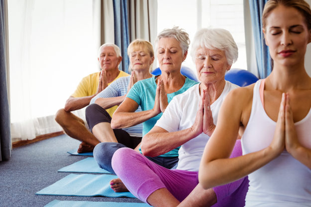 Front view of seniors relaxing with fitness instructor